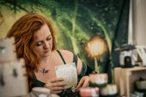 Aurore, creatrice de Merydar, assise en exterieur en train d'ecrire pres d'une bougie