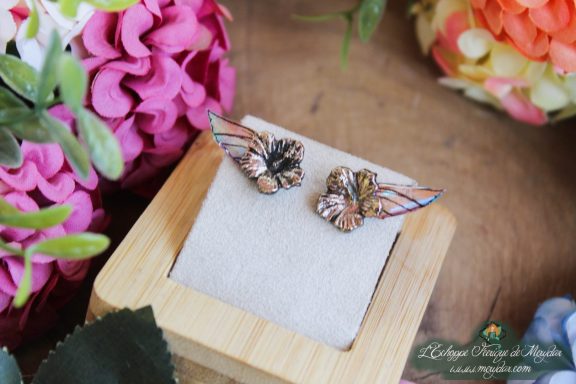 Boucles d'oreilles puce coquillage cuivre, presentees sur socle