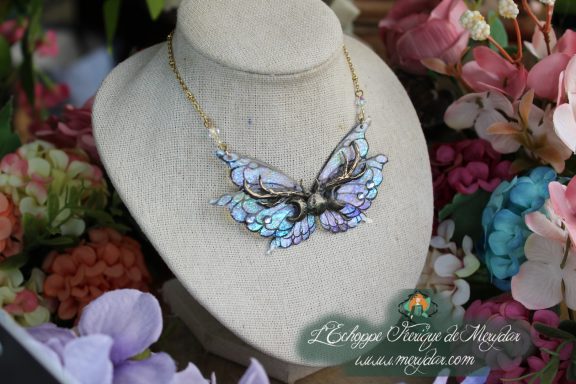 Collier ailes bleu violet holographiques avec perle de lune, gros plan