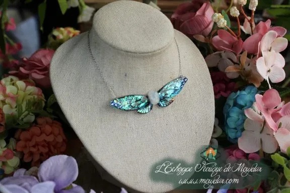 Collier tete de cerf argentee avec ailes bleu violet et cristaux