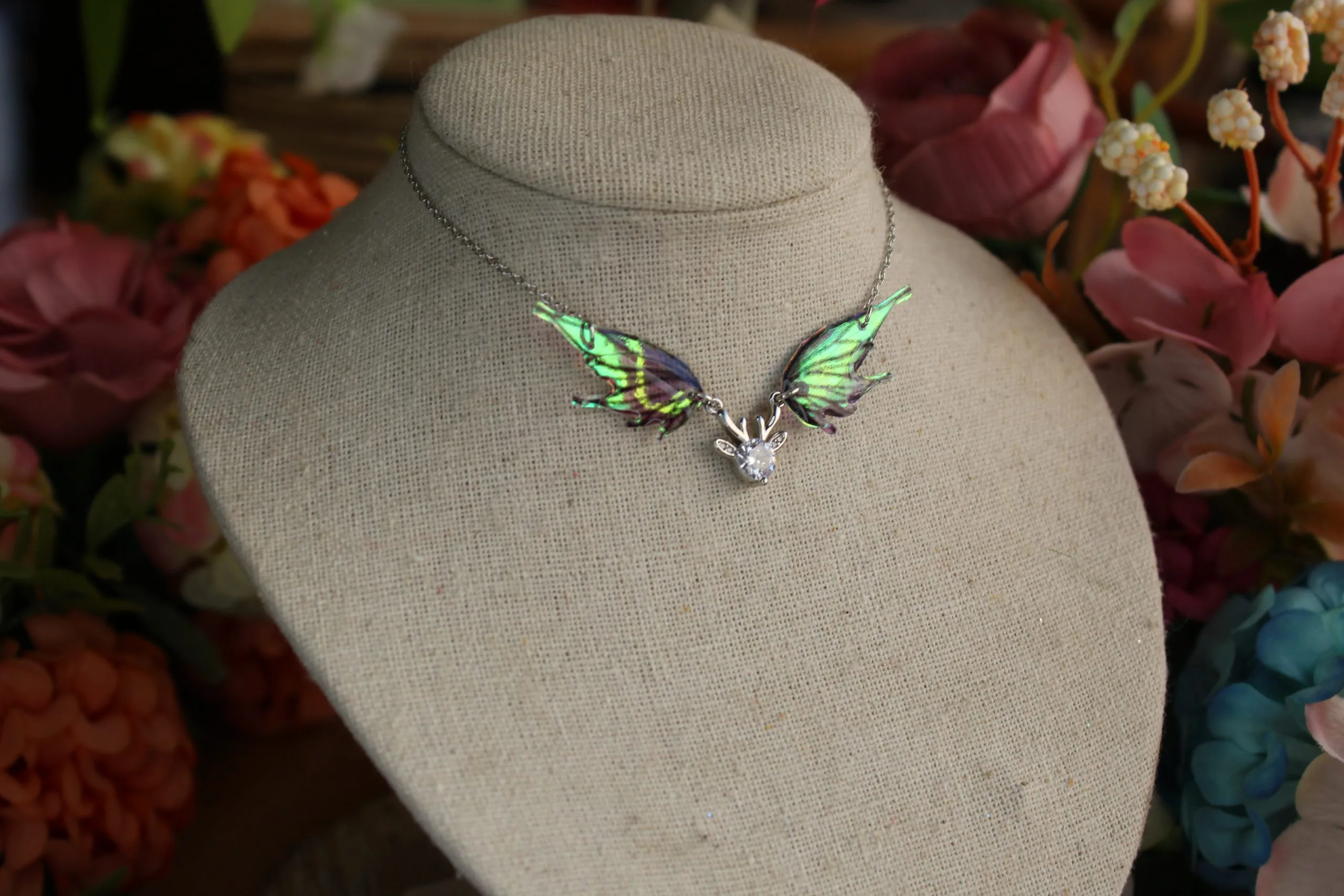 Pendentif féerique avec un petit renne entouré de deux ailes de fée déployées