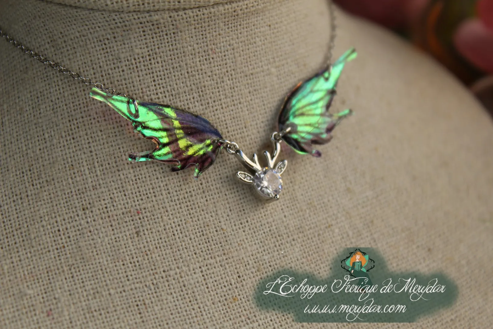 Pendentif féerique avec un petit renne entouré de deux ailes de fée déployées