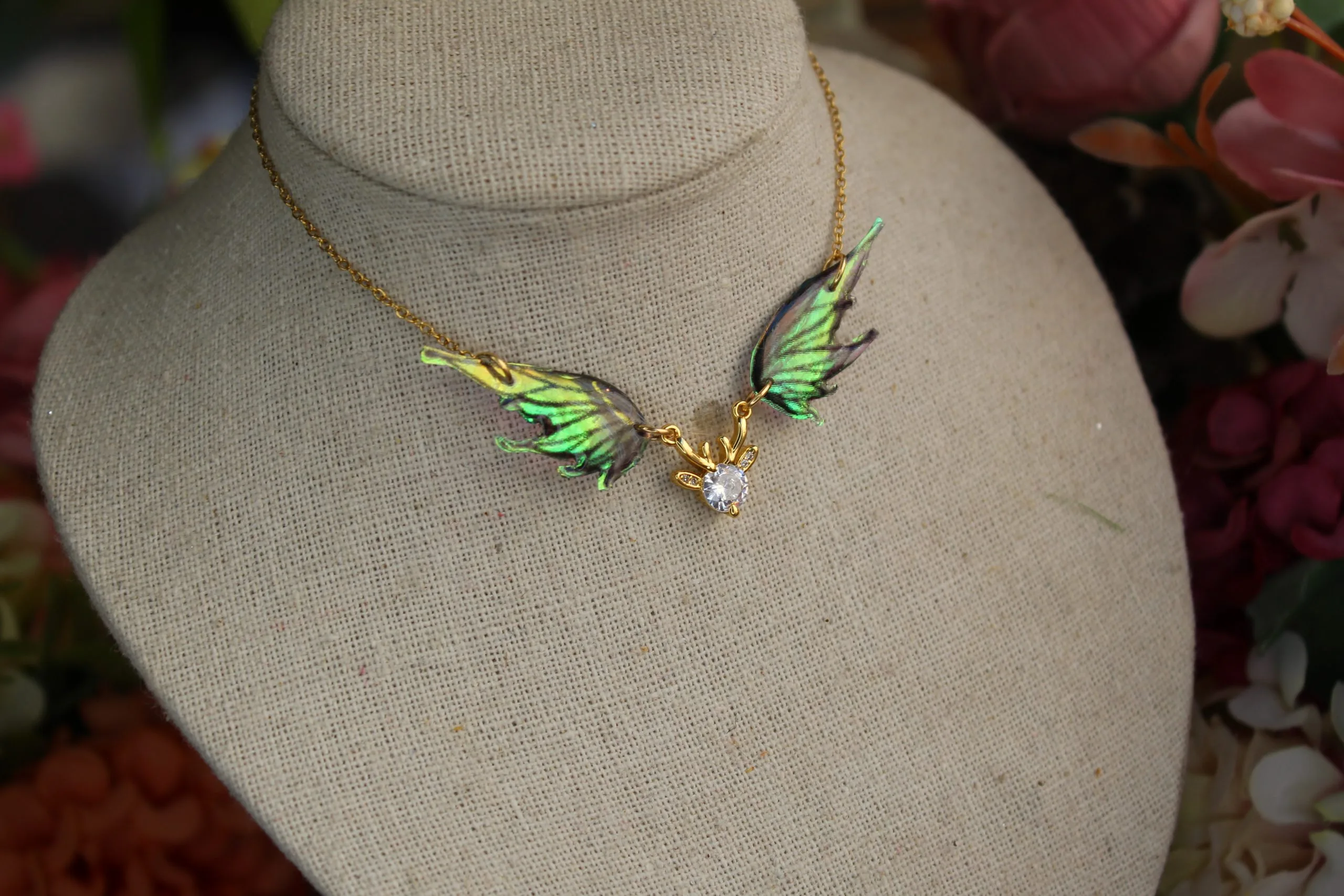 Pendentif féerique avec un petit renne entouré de deux ailes de fée déployées