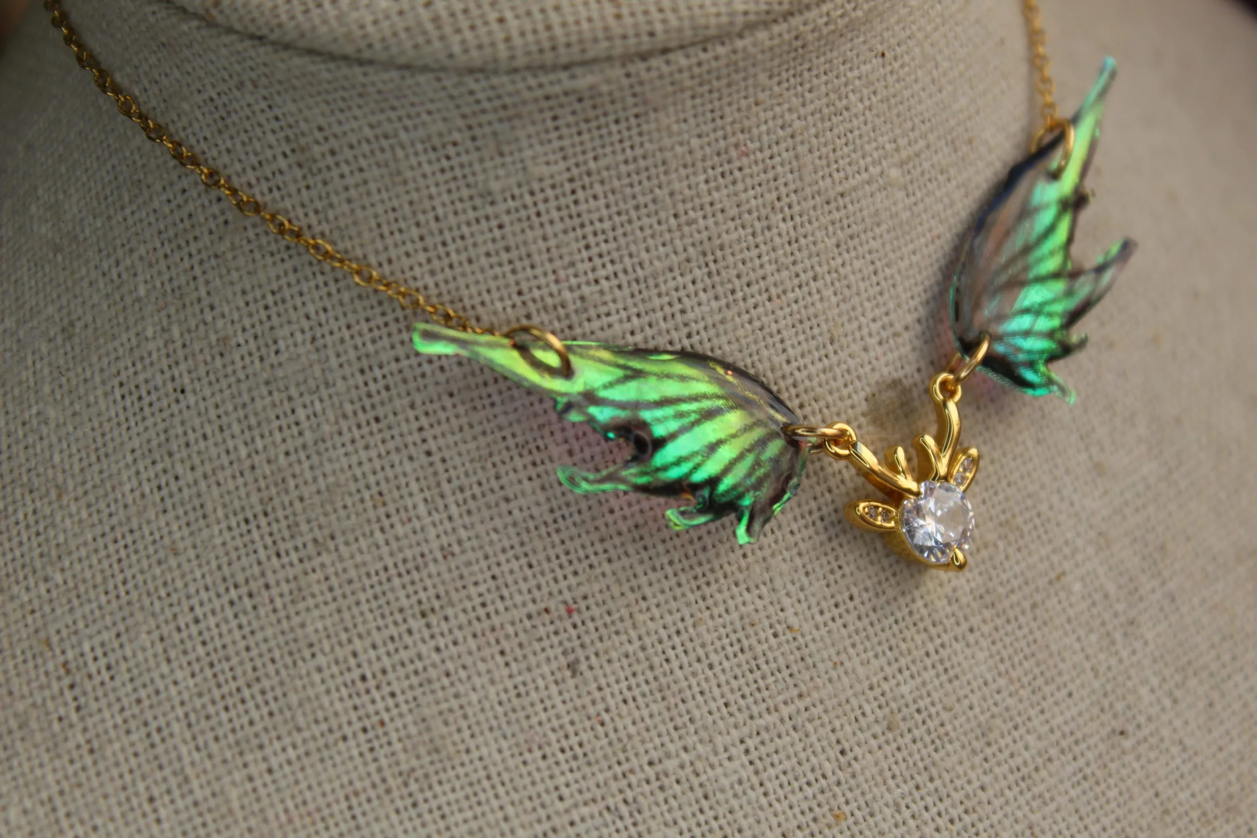Pendentif féerique avec un petit renne entouré de deux ailes de fée déployées