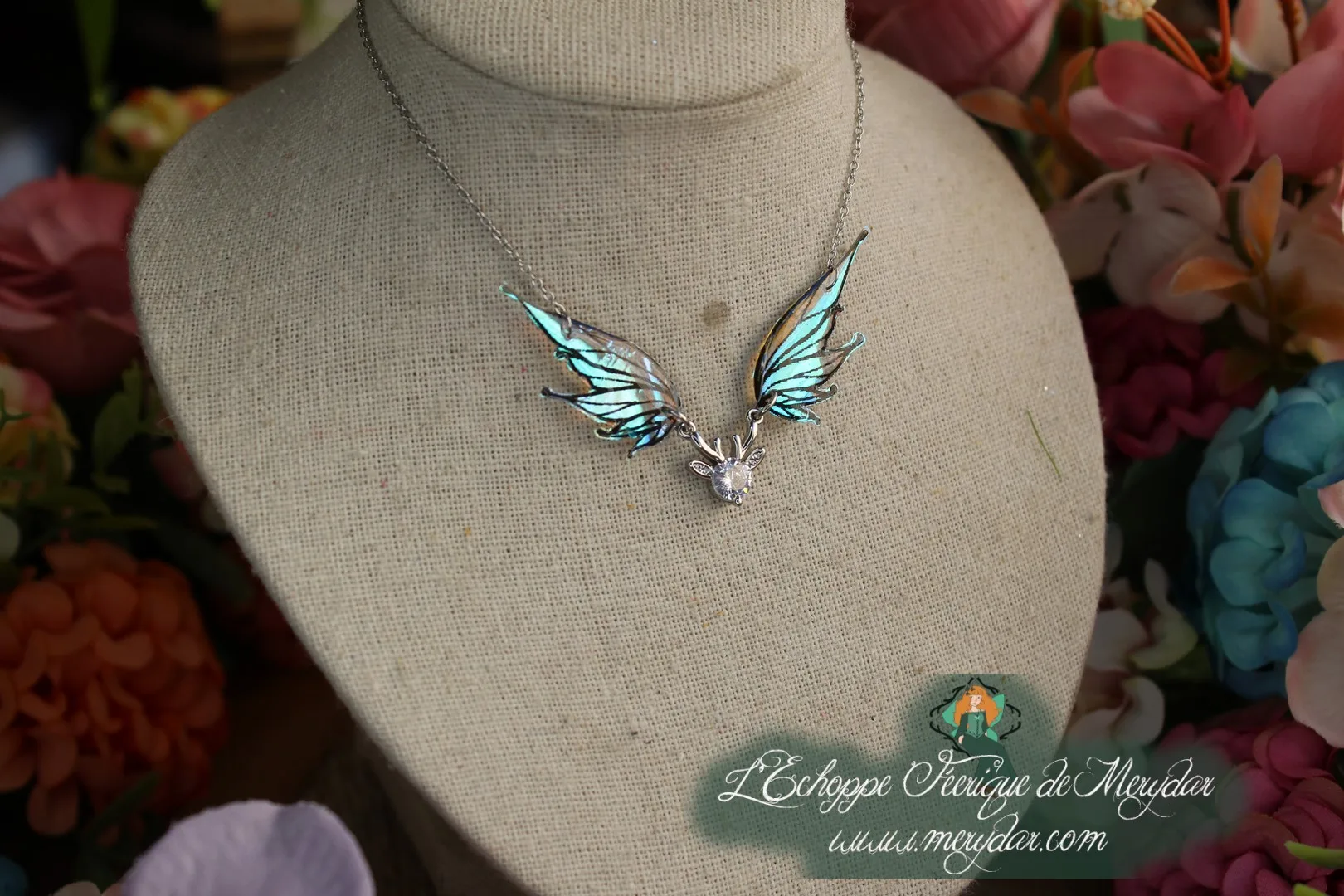 Pendentif féerique avec un petit renne entouré de deux ailes de fée déployées