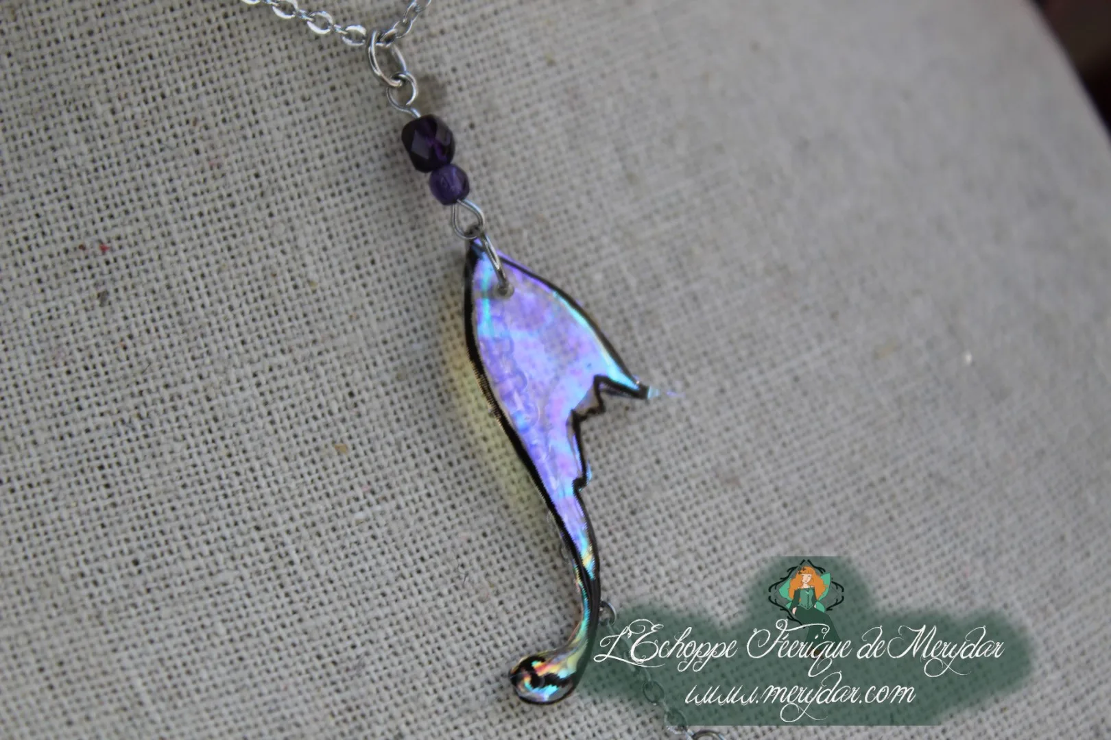 Pendentif aile violette allongee de forme stylisee, sur chaine