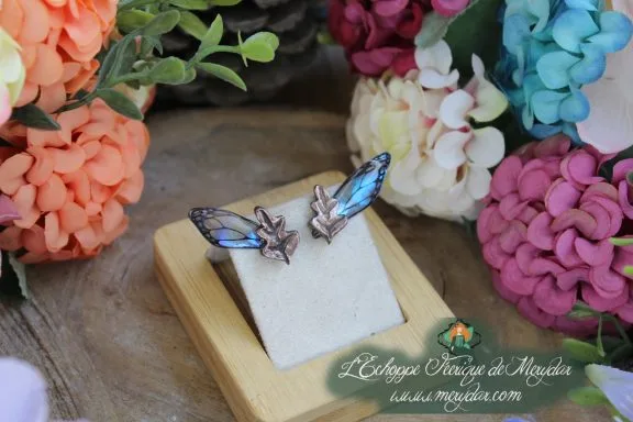 Boucles d'oreilles ailes bleues avec breloque etoile, sur socle