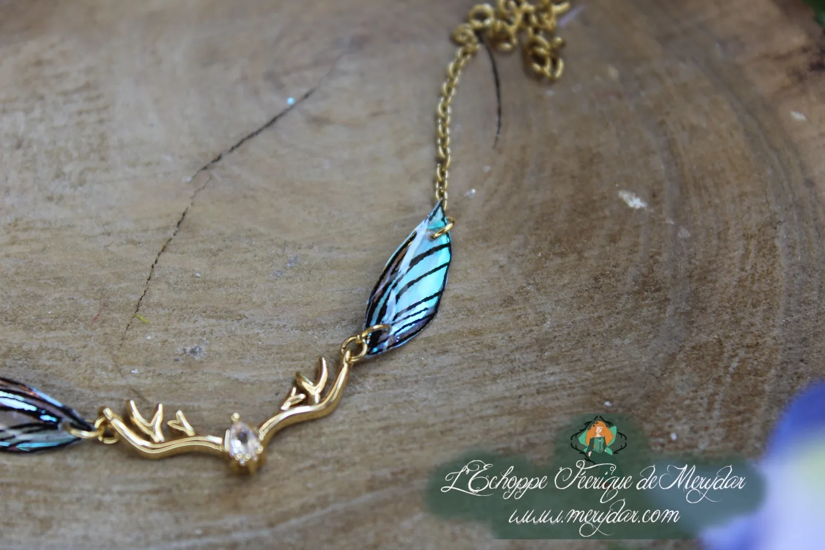 Bracelet dore avec aile bleu vert sur ramure et cristal
