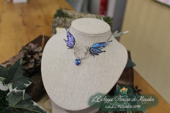 Collier petites ailes bleues formant un pendentif en V avec gemme bleue, sur buste