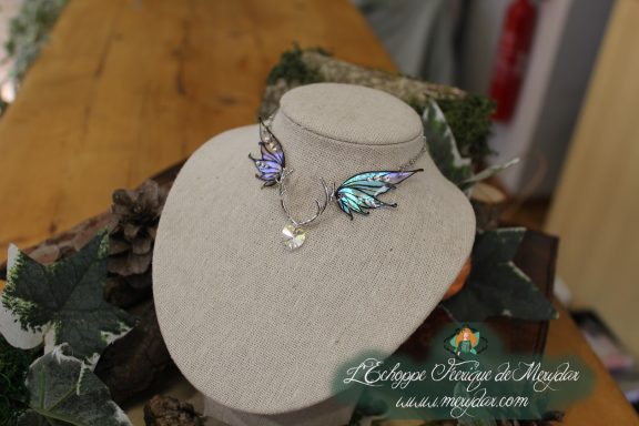 Boucles d'oreilles petites ailes turquoise violette, presentees sur buste
