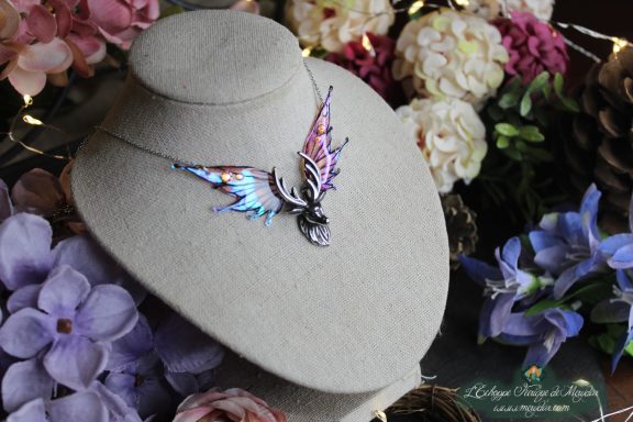 Collier aile de papillon rose et violette avec couronne doree et cristal, sur buste fleuri