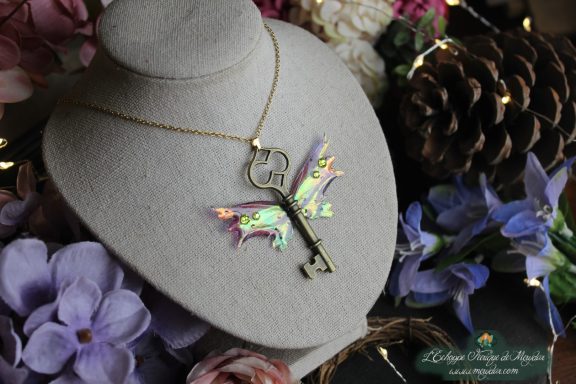 Collier aile de chauve-souris feerique verte avec breloque cle, vue sur buste fleuri