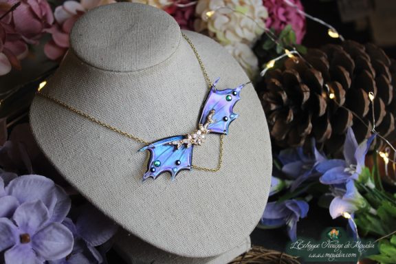 Collier double aile de dragon feerique bleue avec breloque argentee, sur buste fleuri