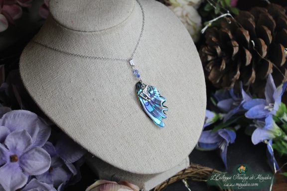 Collier pendentif aile allongee bleue irisee, suspendu verticalement sur chaine