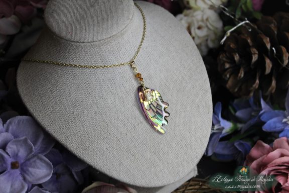 Collier pendentif aile allongee dore et vert, vue sur buste fleuri