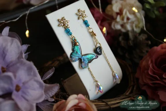 Boucle d'oreille longue papillon turquoise et perles bleues en chute, gros plan