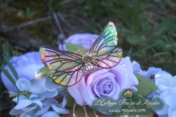 Serre-tete aile de papillon multicolore irisee, pose sur fleurs