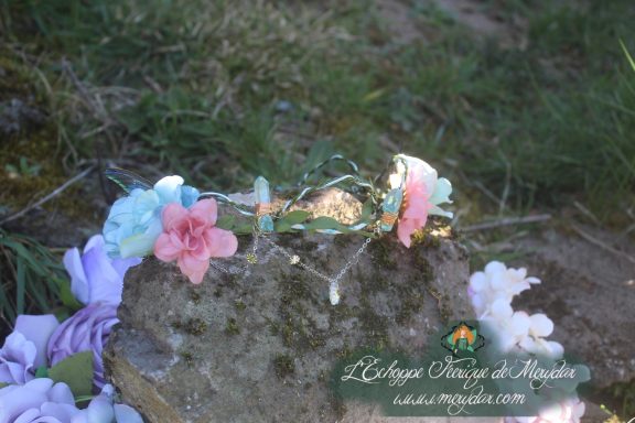 Couronne de fleurs blanches et roses posee sur une pierre en exterieur
