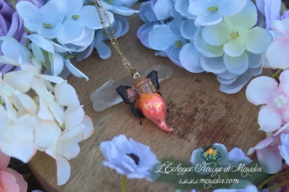 Collier fiole poussiere de fee orange, pendentif aile de papillon, gros plan