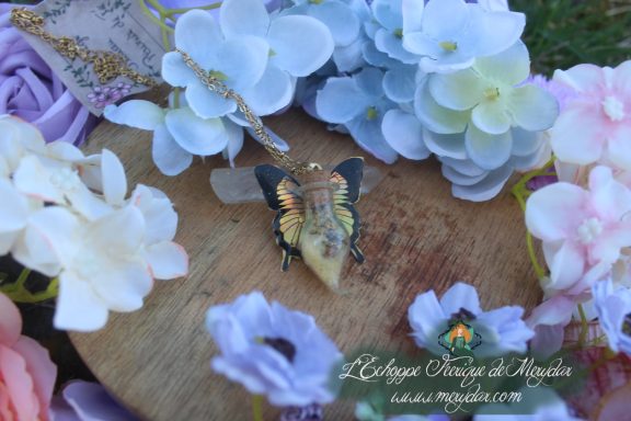 Collier fiole poussiere de fee jaune orange, pendentif aile de papillon, gros plan