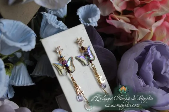 Boucles d'oreilles asymetriques papillon violet et bleu avec perles de cristal, sur carte