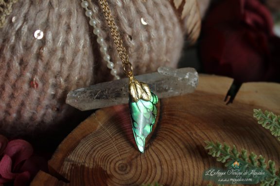 Pendentif aile unique turquoise et verte, presente sur socle en bois avec cristal