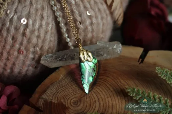 Pendentif aile unique turquoise et verte, presente sur socle en bois avec cristal