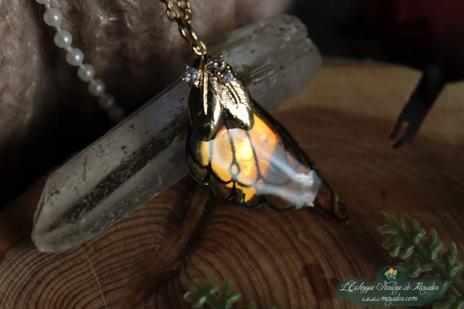 Pendentif aile unique dore et blanche avec breloque feuille, vue rapprochee variante