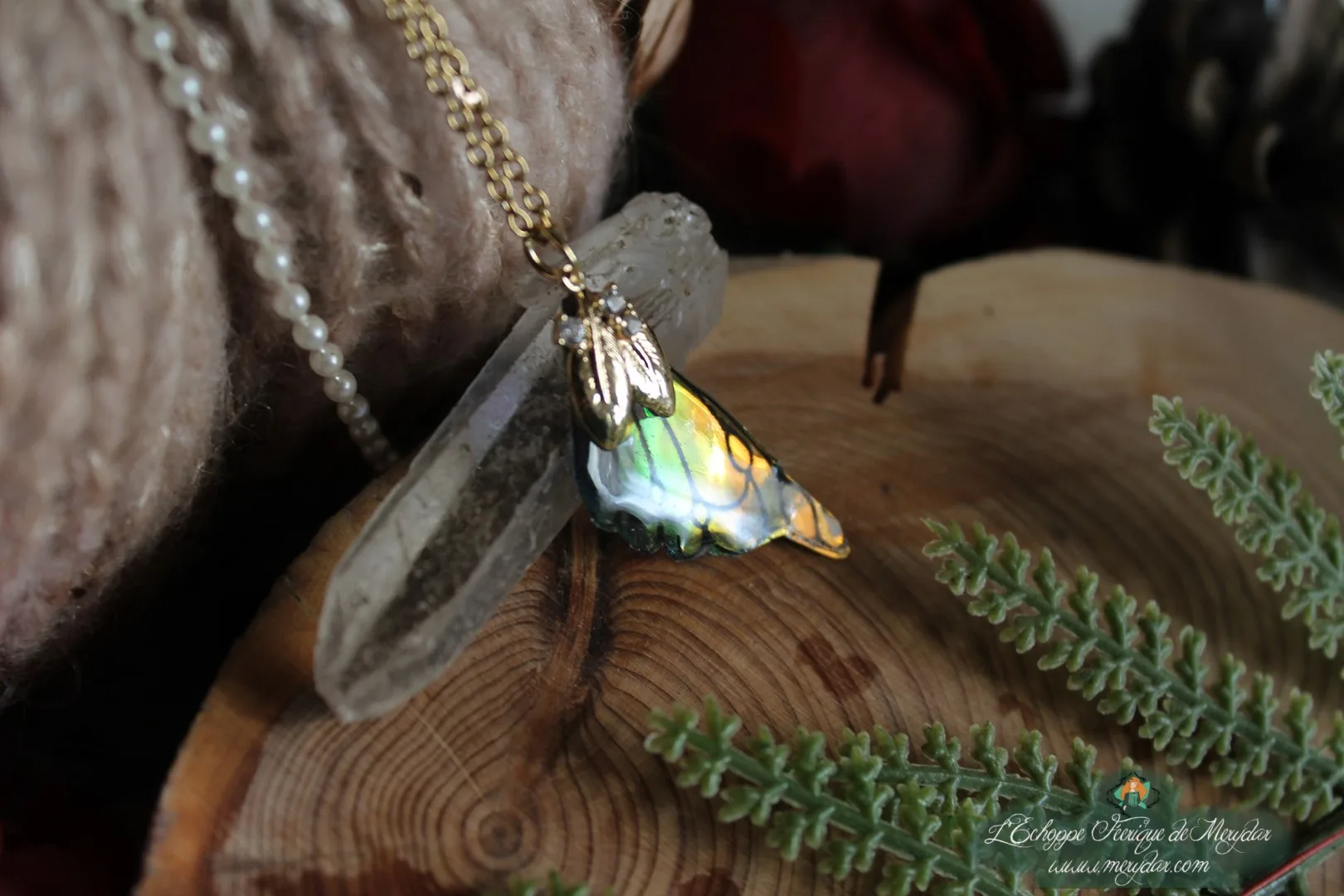 Pendentif aile unique dore et blanche avec breloque feuille, gros plan