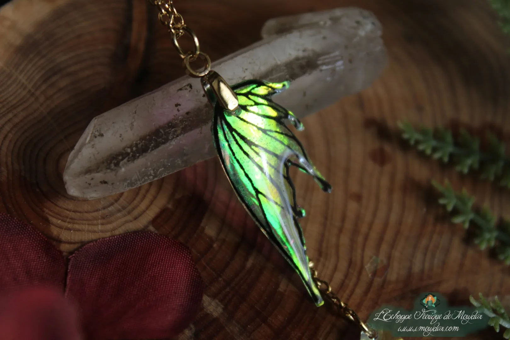 Pendentif fine aile verte, presente sur socle en bois avec cristal