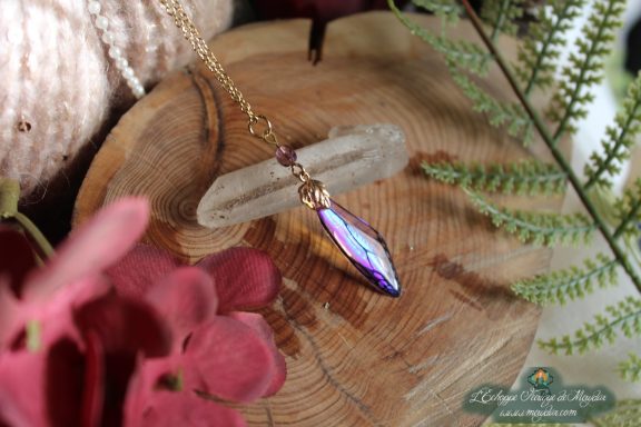 Pendentif fine aile violette avec perle pendante, presente sur socle en bois