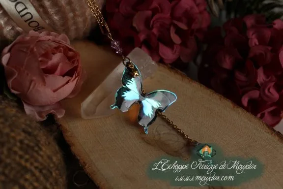 Collier pendentif papillon turquoise bleu entier, presente sur socle en bois fleuri
