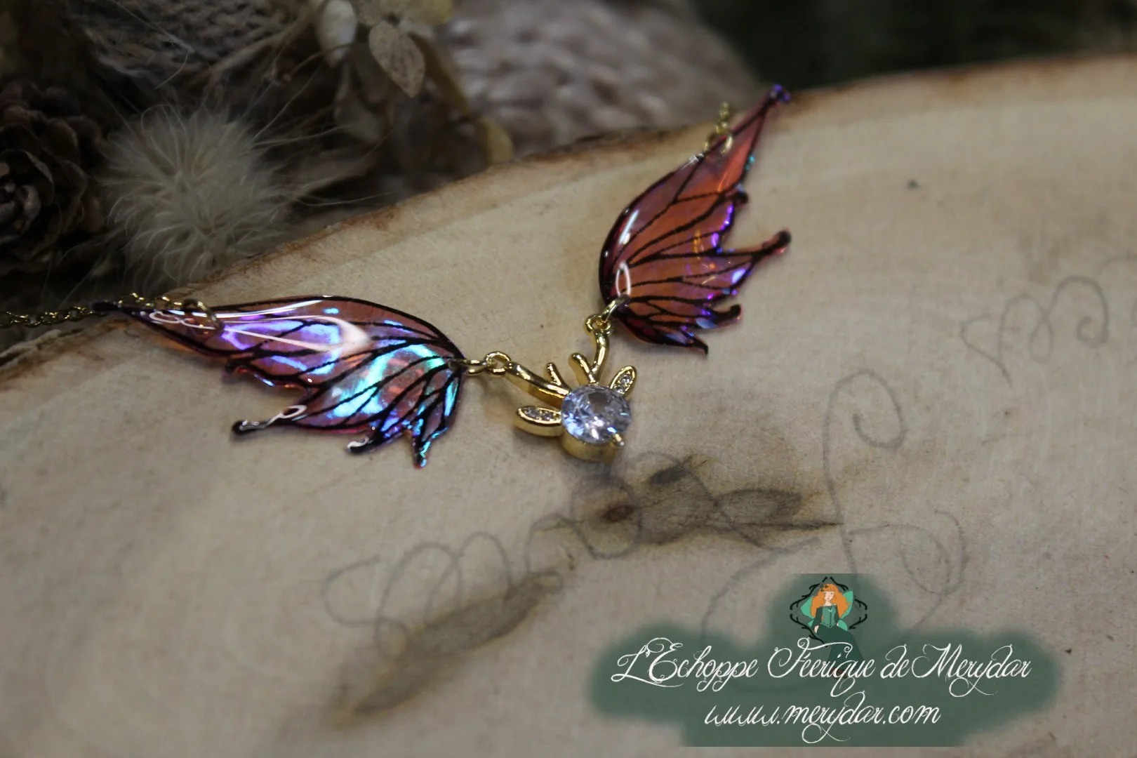 Pendentif féerique avec un petit renne entouré de deux ailes de fée déployées