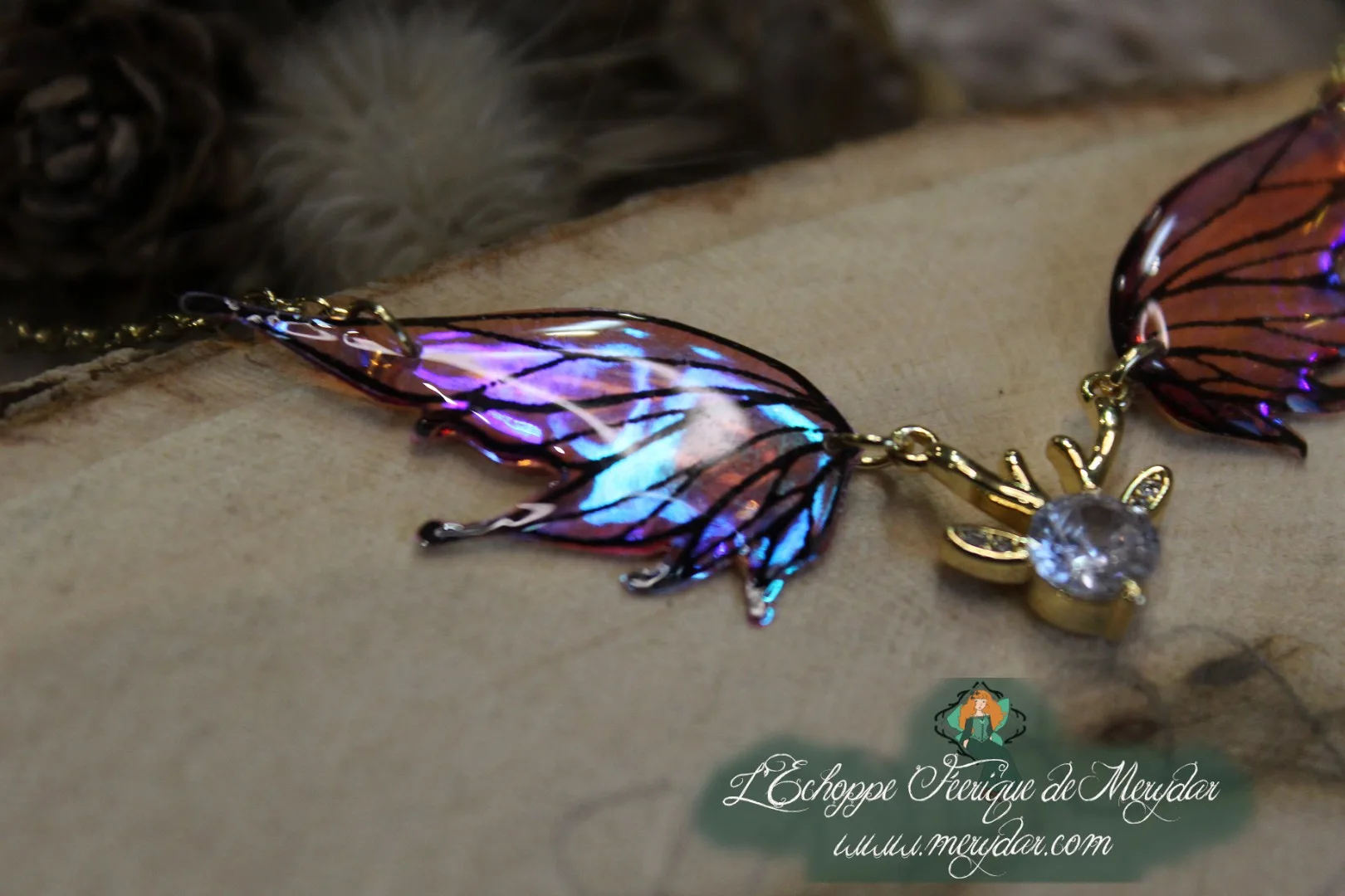 Pendentif féerique avec un petit renne entouré de deux ailes de fée déployées