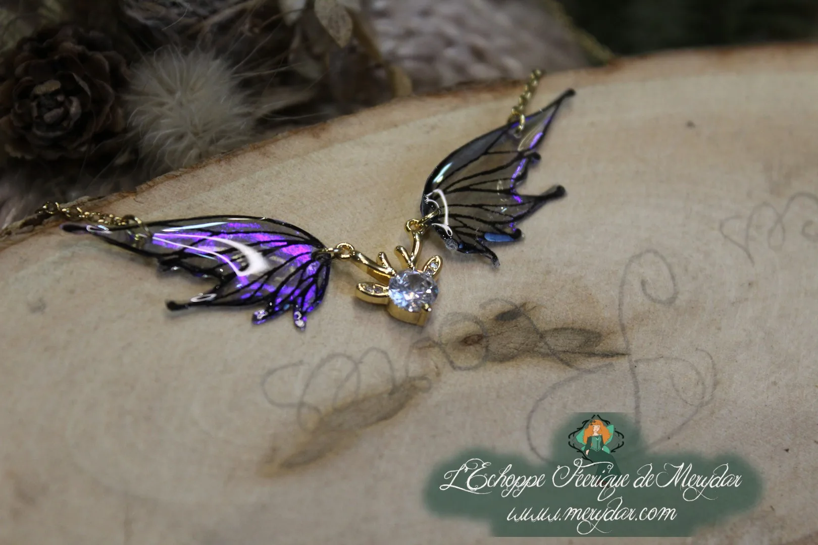 Pendentif féerique avec un petit renne entouré de deux ailes de fée déployées