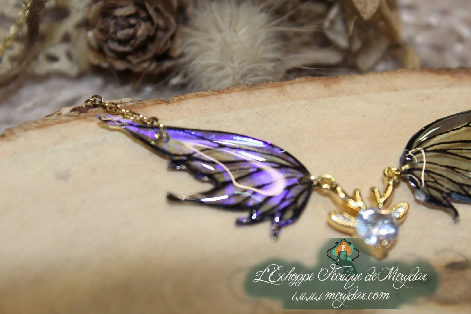 Pendentif féerique avec un petit renne entouré de deux ailes de fée déployées
