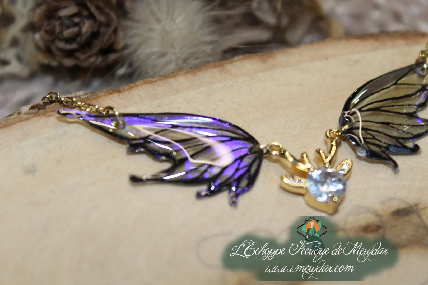 Pendentif féerique avec un petit renne entouré de deux ailes de fée déployées