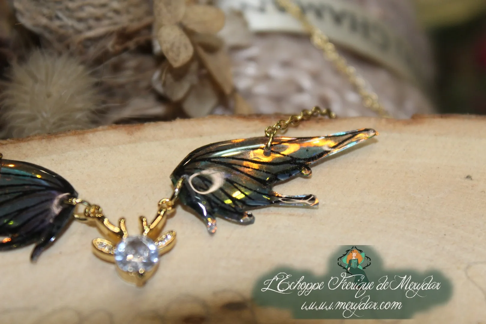 Pendentif féerique avec un petit renne entouré de deux ailes de fée déployées