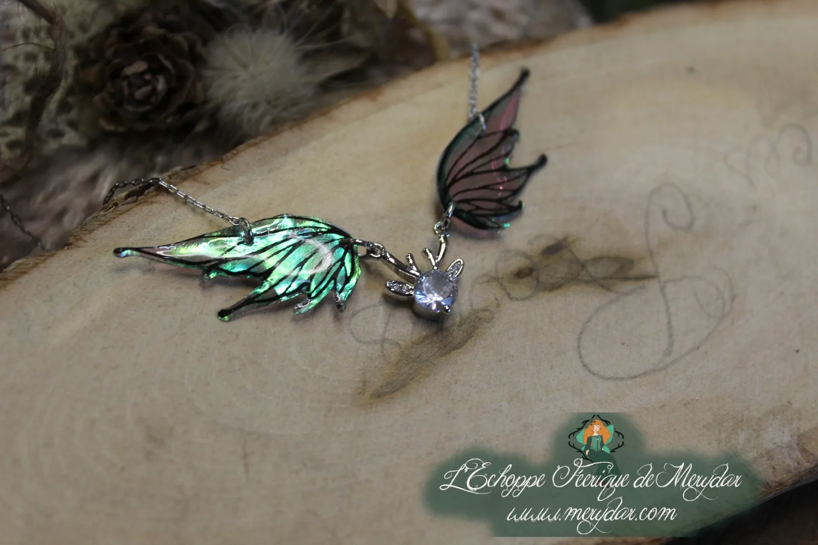 Pendentif féerique avec un petit renne entouré de deux ailes de fée déployées