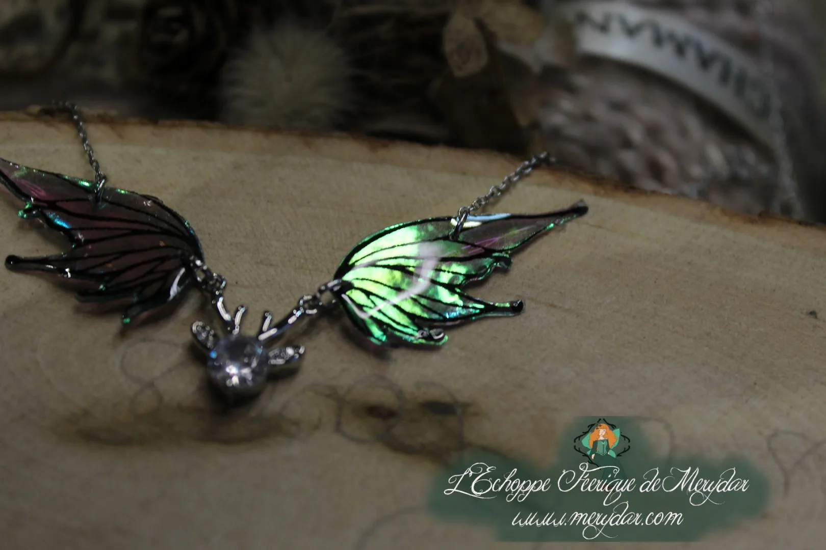 Pendentif féerique avec un petit renne entouré de deux ailes de fée déployées
