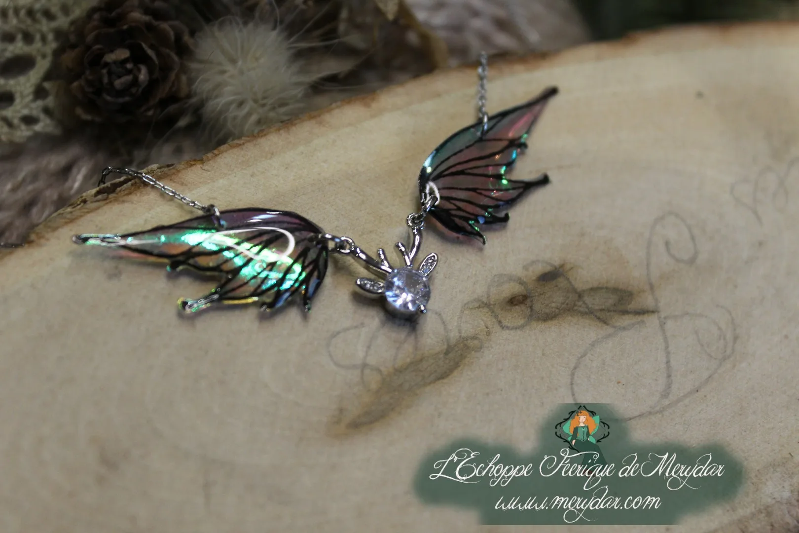 Pendentif féerique avec un petit renne entouré de deux ailes de fée déployées