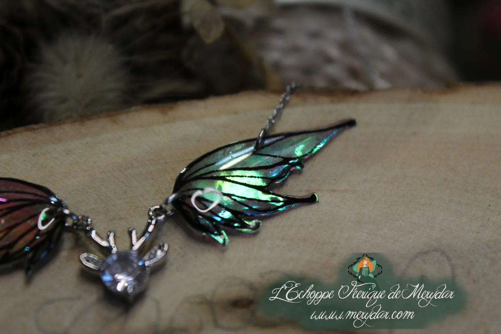 Pendentif féerique avec un petit renne entouré de deux ailes de fée déployées