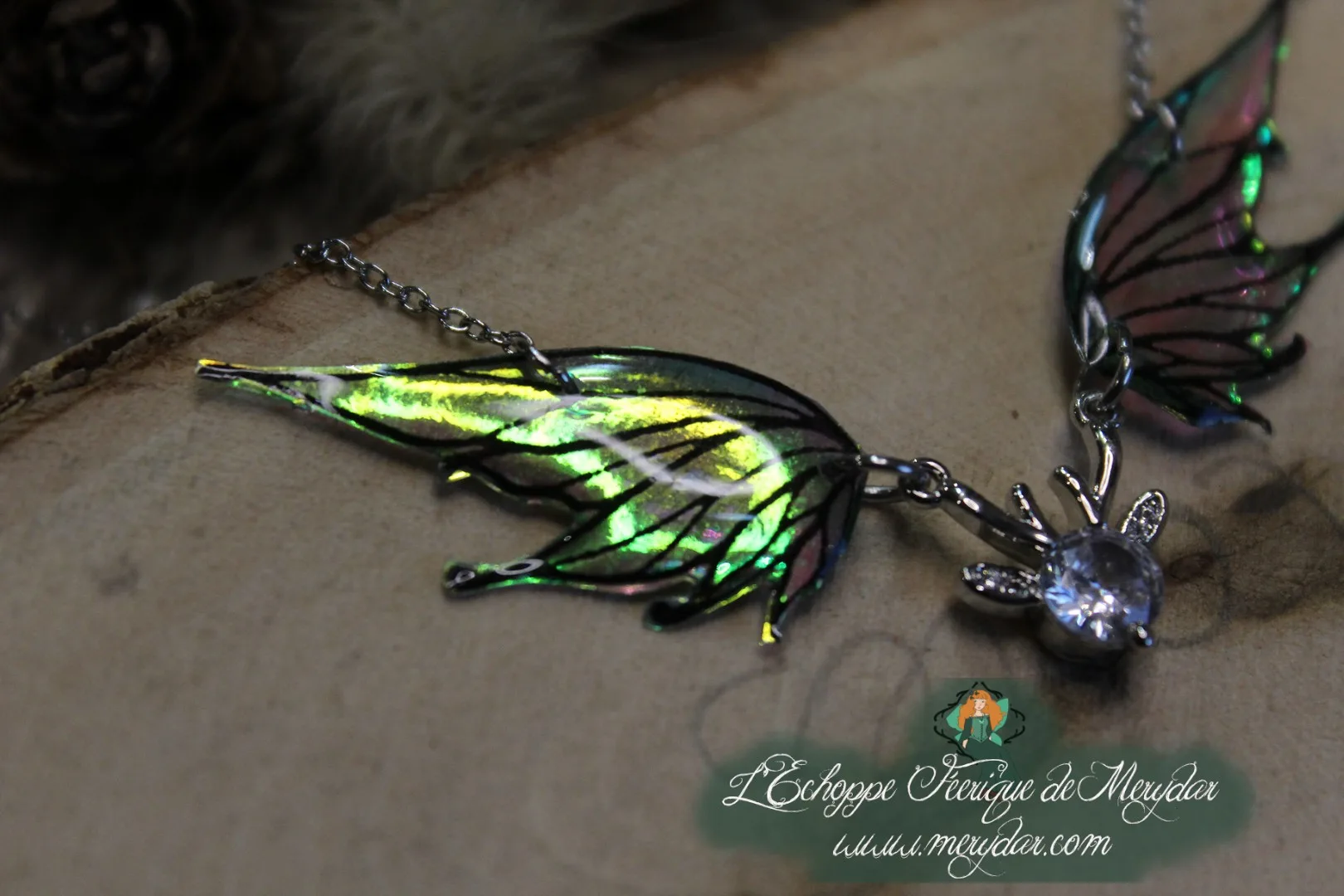 Pendentif féerique avec un petit renne entouré de deux ailes de fée déployées
