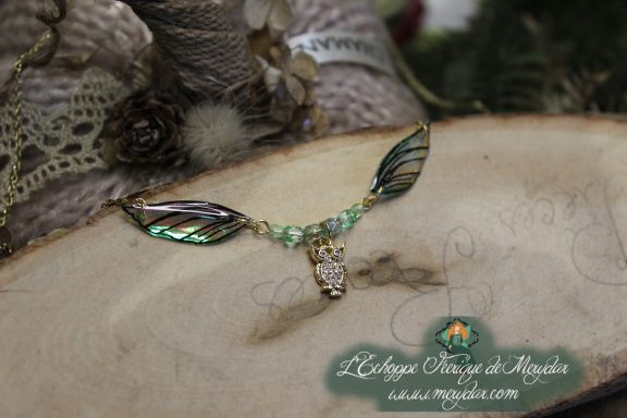 Collier pendentif branche doree avec deux ailes vertes et breloque hibou, perles vertes, gros plan