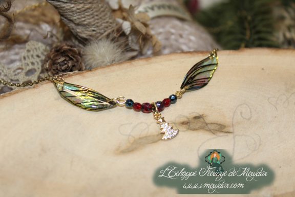 Collier pendentif branche doree avec deux ailes vertes et breloque fee, perles rouges, gros plan