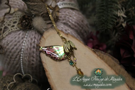 Pendentif aile rose verte avec perles pendantes, gros plan sur bois