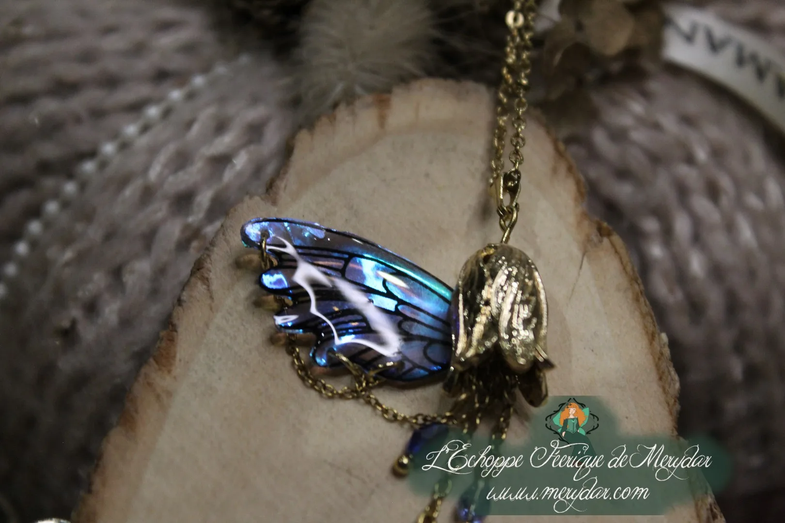 Pendentif aile bleue violette avec breloque sombre pendante, gros plan sur bois