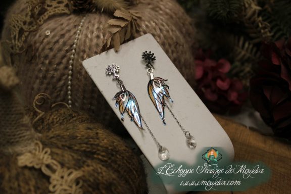 Boucles d'oreilles longues depareillees argentees et bleues, vue rapprochee sur carte