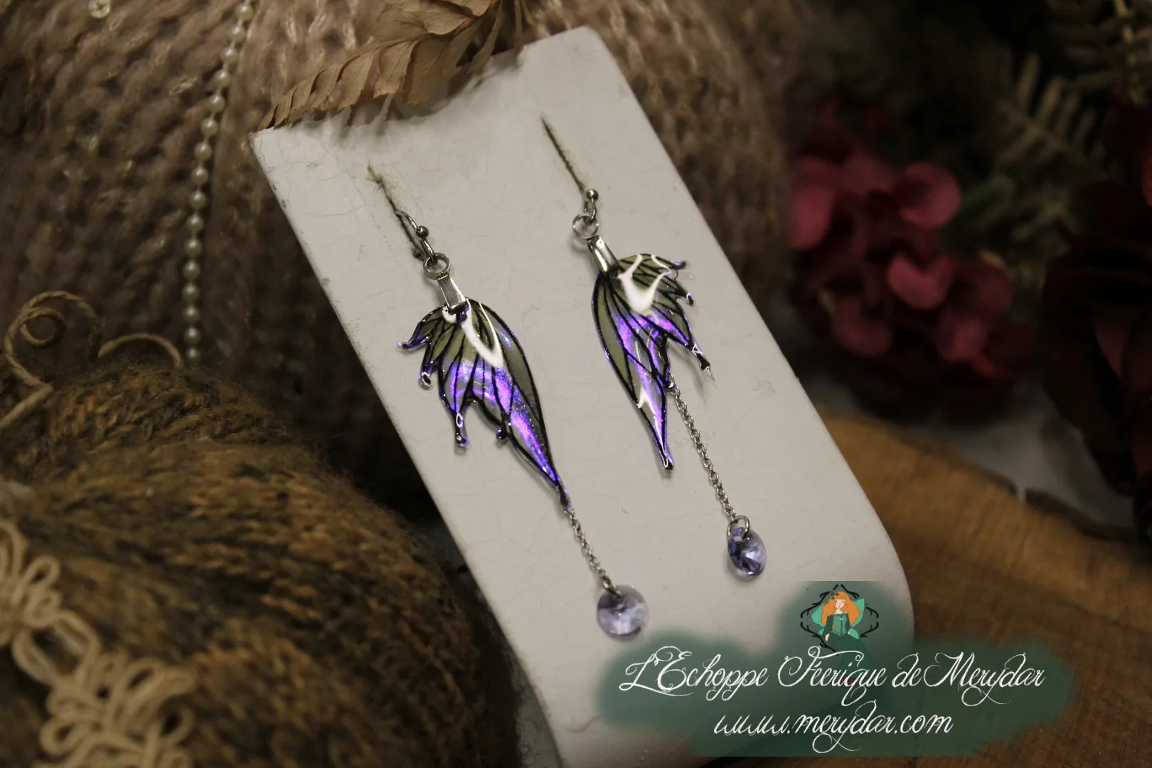 Boucles d'oreilles longues depareillees violettes avec perles, sur carte