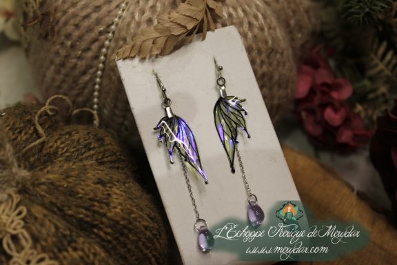 Boucles d'oreilles longues depareillees violettes et vertes, sur carte